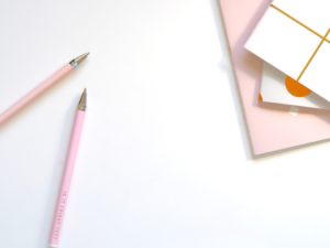 Pink pens and pink notebook on a white background