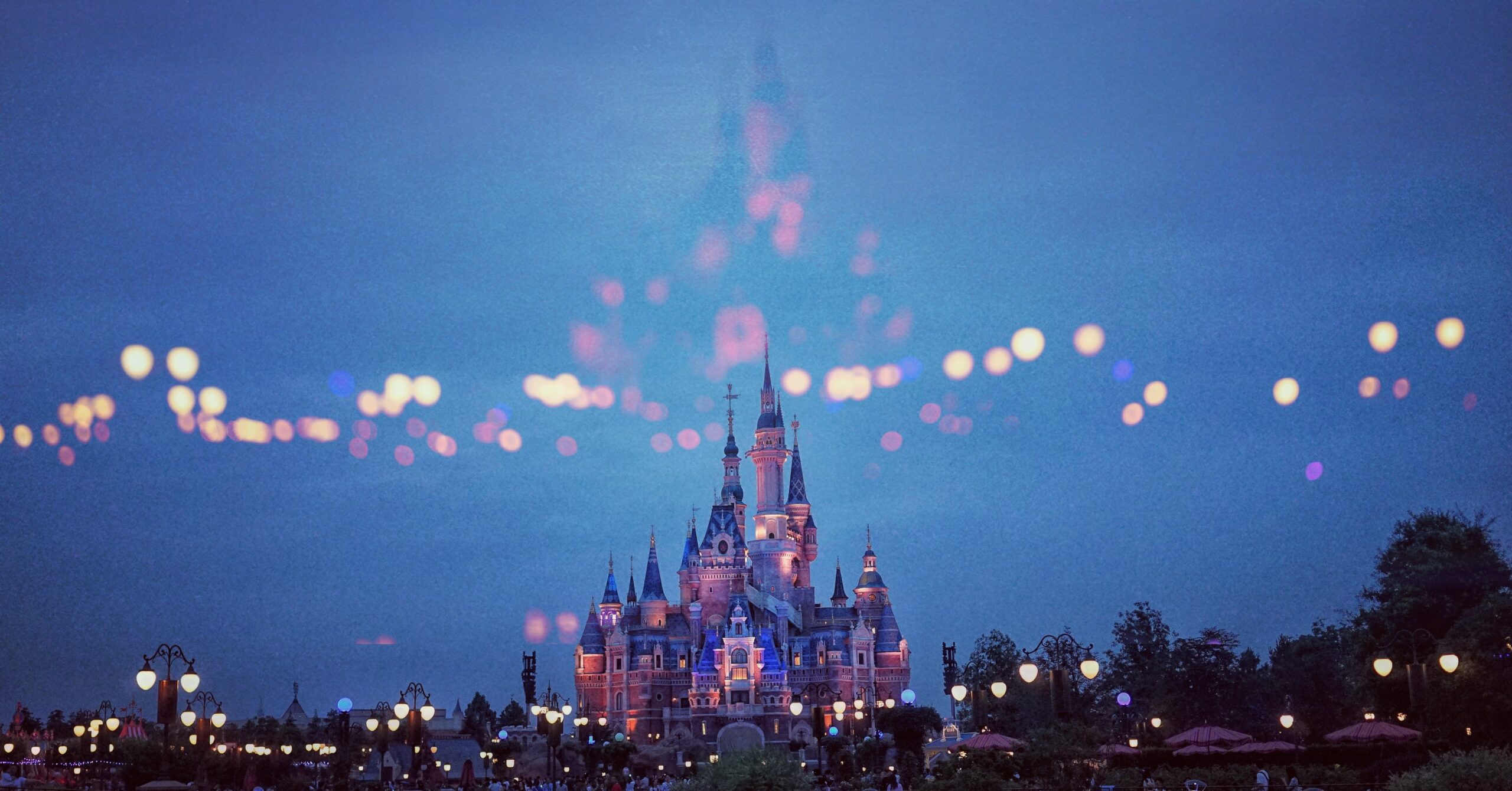 Image of the Disney castle at night. Dark blue sky and out of focus lights.